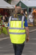 Person in yellow safety waistcoat on a market square, Sindelfingen, Böblingen district, Germany