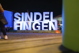 Illuminated welcome sign at night with colourful surroundings and festive atmosphere, Sindelfingen,