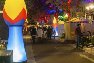 A busy city street at night, illuminated by colourful lamps and lights, Sindelfingen, Böblingen