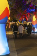 People walking at night on a street illuminated with colourful lights, Sindelfingen, Böblingen