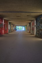 View through an artistically painted tunnel onto a green environment, Munich, Germany
