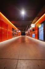 Bright red corridor with doors and neon lights at night, Munich, Germany