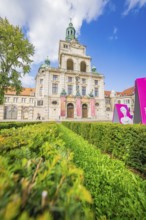 Magnificent historic building with towers and green gardens under a blue sky, Munich, Germany