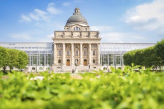 Large building with dome, surrounded by green spaces, cloudless sky and impressive architecture,