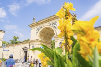 Historic Tor tor with yellow flowers in the foreground and blossoming sky and architecture in the