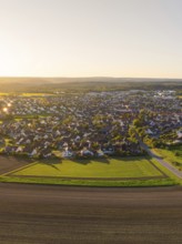 Aerial view of a village surrounded by fields at sunset with rural charm, Althengstett, district of