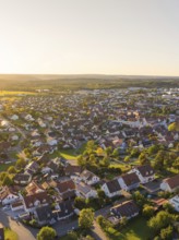 Aerial view of a village at sunset with many houses, trees and rural atmosphere, Althengstett,
