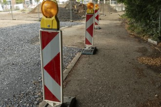 Borken, NRW, Germany, Red and white striped warning posts with flashing orange lights marking a