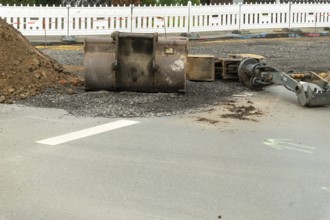 Borken, NRW, Germany, Excavator bucket and arm resting on gravel during road construction or repair