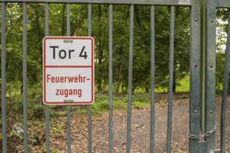 Borken, NRW, Germany, Metal gate displaying a feuerwehrzufahrt sign, providing entry to a forest