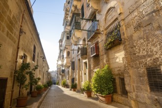 Street with wonderful historic houses with colorful wooden balconies in La Valletta, capital city