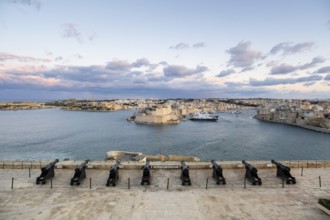 Beautiful sunset view of Valletta with a cannons in the foreground, capital city of Malta