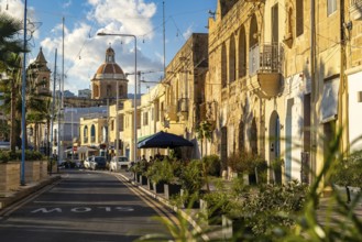 Charming street with limestone building and Saint Mary church at the end, fisherman village of