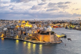 Beautiful evening view of illuminated Valletta, Birgu with Saint Angelo Fortress, capital city of