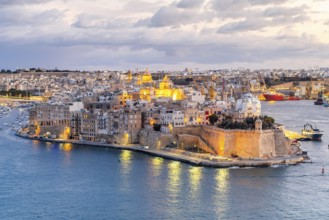 Beautiful evening view of illuminated Valletta, Birgu with Saint Angelo Fortress, capital city of