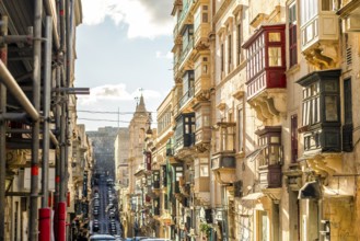 Street with amazing historic houses with colorful wooden balconies in La Valletta, capital city of