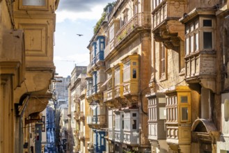 Street with amazing historic houses with colorful wooden balconies in La Valletta, capital city of