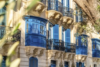 Street with amazing historic houses with colorful wooden balconies in La Valletta, capital city of