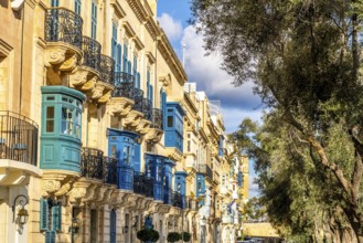 Street with amazing historic houses with colorful wooden balconies in La Valletta, capital city of