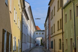 Narrow cobblestone alleyway between colourful historic buildings under a clear sky, Waffnergasse,
