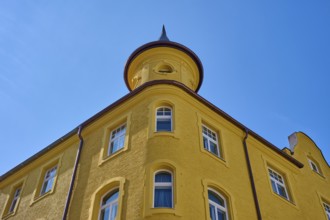 Yellow building with round tower and windows in front of a clear sky, Regensburg, Bavaria, Germany