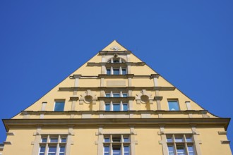 Building with striking triangular gable and windows against a clear sky, Regensburg, Bavaria,