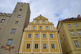 Yellow and sand-coloured building with striking tower and blue sky in Regensburg, Regensburg,