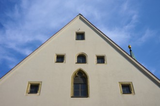Gable of an old building with Gothic windows in front of a blue sky, Regensburg, Bavaria, Germany