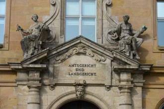 Historic façade of a court building with decorative sculptures and classical architecture, district