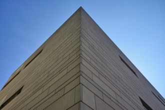 Modern architecture with clear lines and geometric shapes, hit by sunlight under a blue sky,