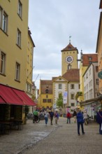Lively pedestrian zone with a view of the tower, surrounded by historic buildings, Regensburg,