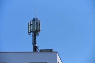Communication tower on the roof of a building under a clear blue sky, Regensburg, Bavaria, Germany