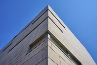 Modern building with concrete façade against a blue sky in minimalist perspective, Regensburg,