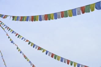 Colourful prayer flags flutter in the blue sky, conveying a feeling of freedom and peace, Bavaria,