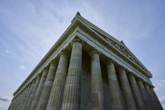 Impressive towering columned building in front of a blue sky in low perspective, Walhalla,