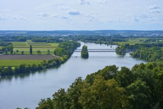 A tranquil river landscape with bridge and trees under a cloudy sky, Walhalla, Donaustauf, Danube,