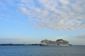 A cruise ship, MSC Euribia, moves through wide waters under a cloudy sky, Heikendorf, Plön