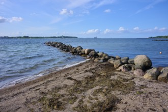 Stone breakwater in the sea on a sunny beach day with blue sky, Heikendorf, Plön district, Kiel