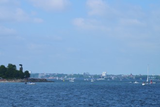 Sea view with sailing boats and a distant city of Kiel on the horizon, Heikendorf, Plön district,
