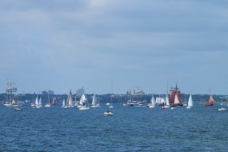 Many sailing boats in front of a city on the blue sea under a partly cloudy sky, Windjammer Parade