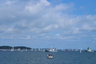 Scattered boats on the sea under a cloudy blue sky, wide visible, Windjammer Parade Kiel 2025,