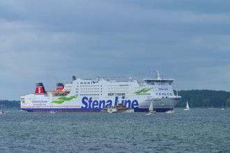 Stena Line ferry surrounded by sailing boats on the sea under a cloudy sky, Windjammer Parade Kiel