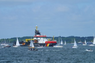 Various sailing boats and a large ship Arkona Coast Guard on a sunlit sea, Windjammer Parade Kiel