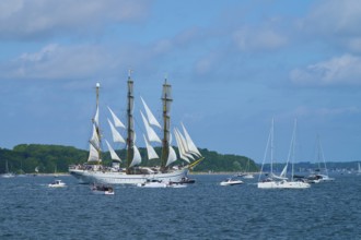 An impressive tall ship Gorch Fock with other boats on a sunny sea, Windjammer Parade Kiel 2025,