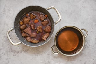 Chunks of tender beef and vegetables are slow-cooked in a pot, creating a hearty stew with dark