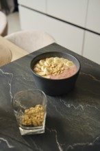 Delicious banana-strawberry smoothie served with pine nuts in a modern kitchen setting