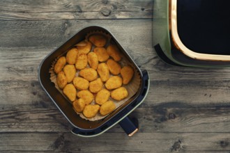 Golden and crispy chicken nuggets fill the air fryer basket, ready to be served as a tasty snack or