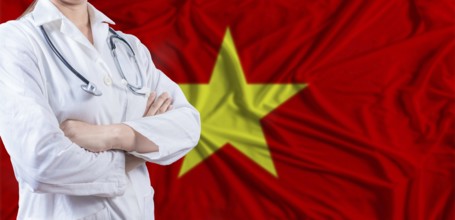 Doctor with crossed arms on Vietnam flag. Vietnam health and care concept. Female doctor on Vietnam