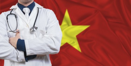 Male doctor with stethoscope on Vietnam flag. Doctor holding stethoscope on Vietnam flag