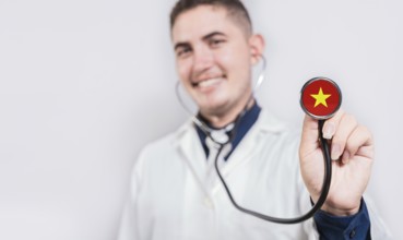 Doctor showing stethoscope with Vietnam flag. Vietnam national healthcare concept